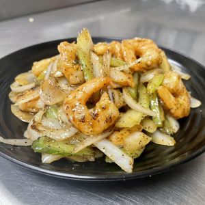 onion, celery in a brown sauce with ground black pepper